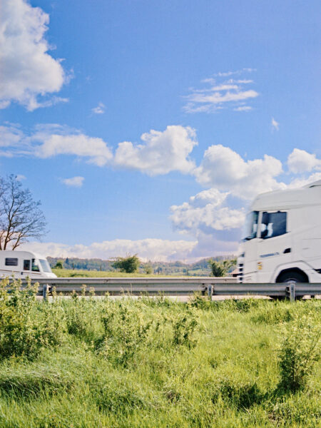 Fine art picture showing a summerly landscape with a white lorry and a white mobile home in the foreground