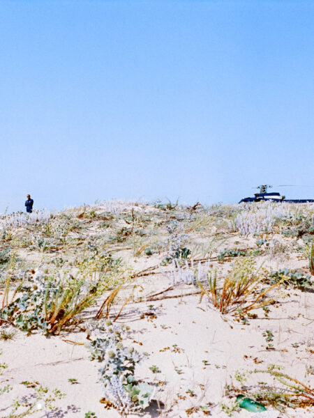 Fine art picture showing a pilot and his helicopter hidden behind a dune