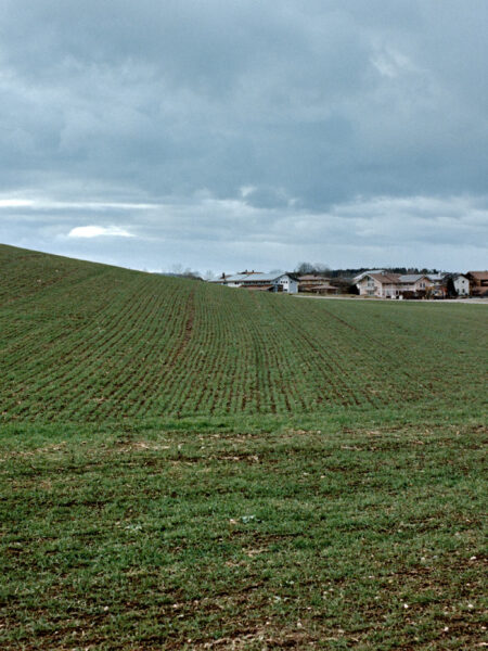 Fine art picture showing a rural landscape in Bavaria with dominating winterly fields in the foreground